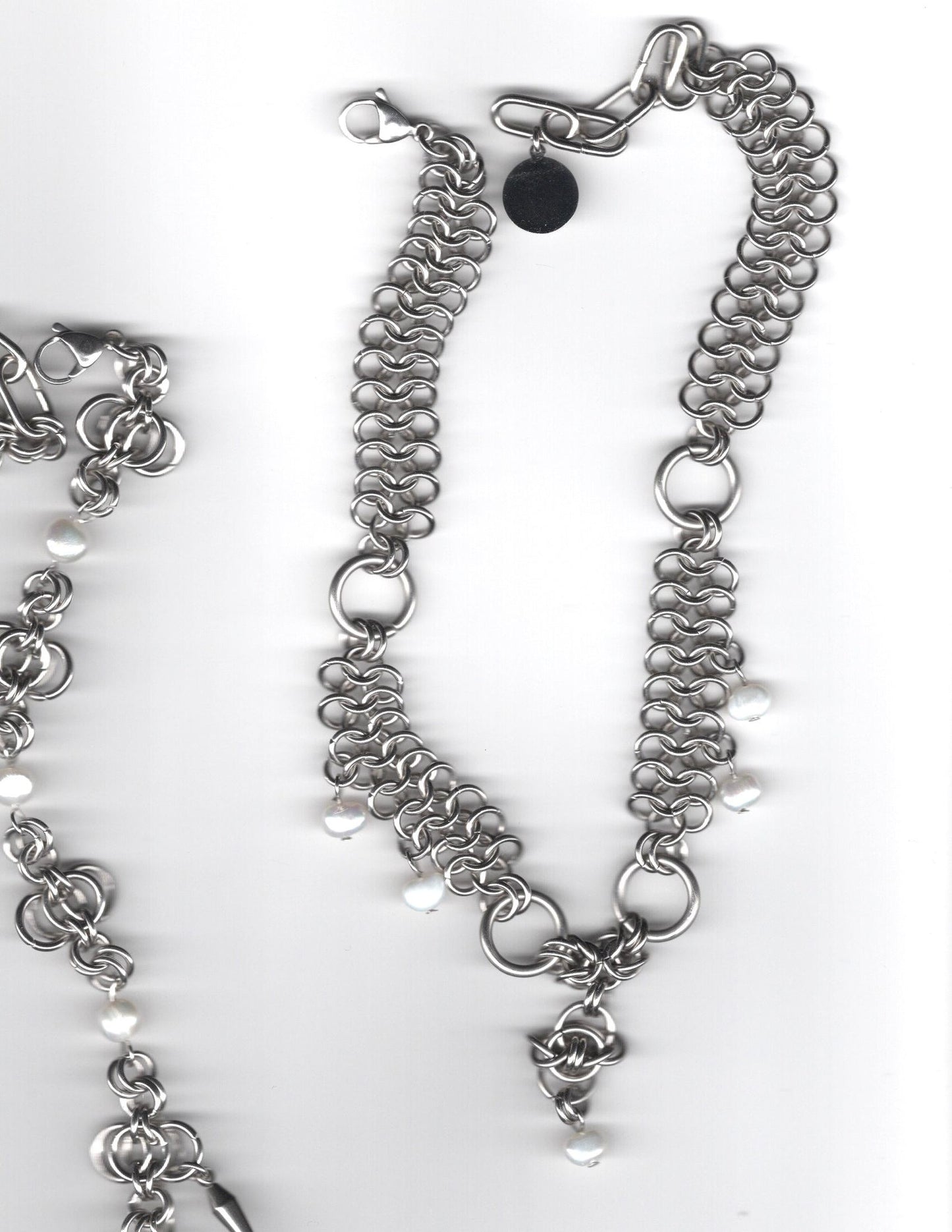 Silver chain necklace with floral charm on a white background