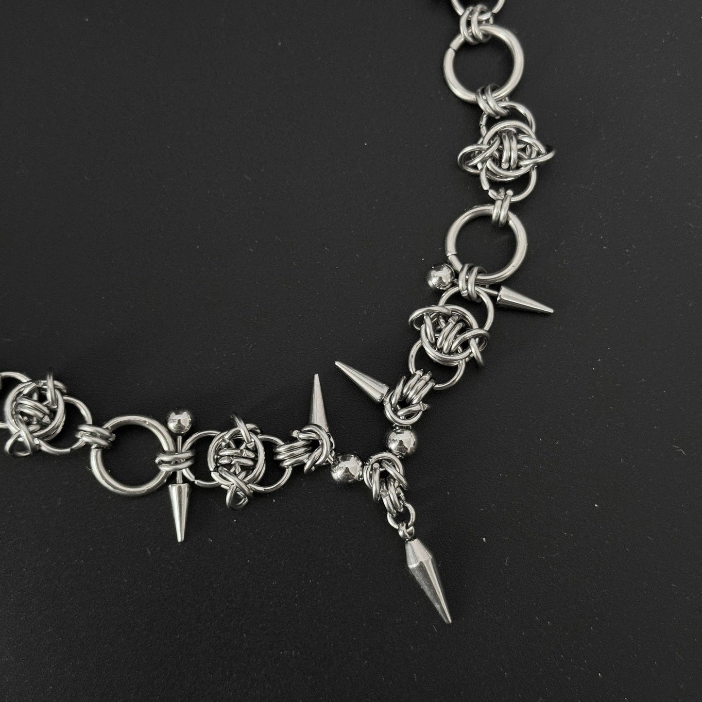 Lay flat photograph of alternative gothic choker necklace in silver stainless steel