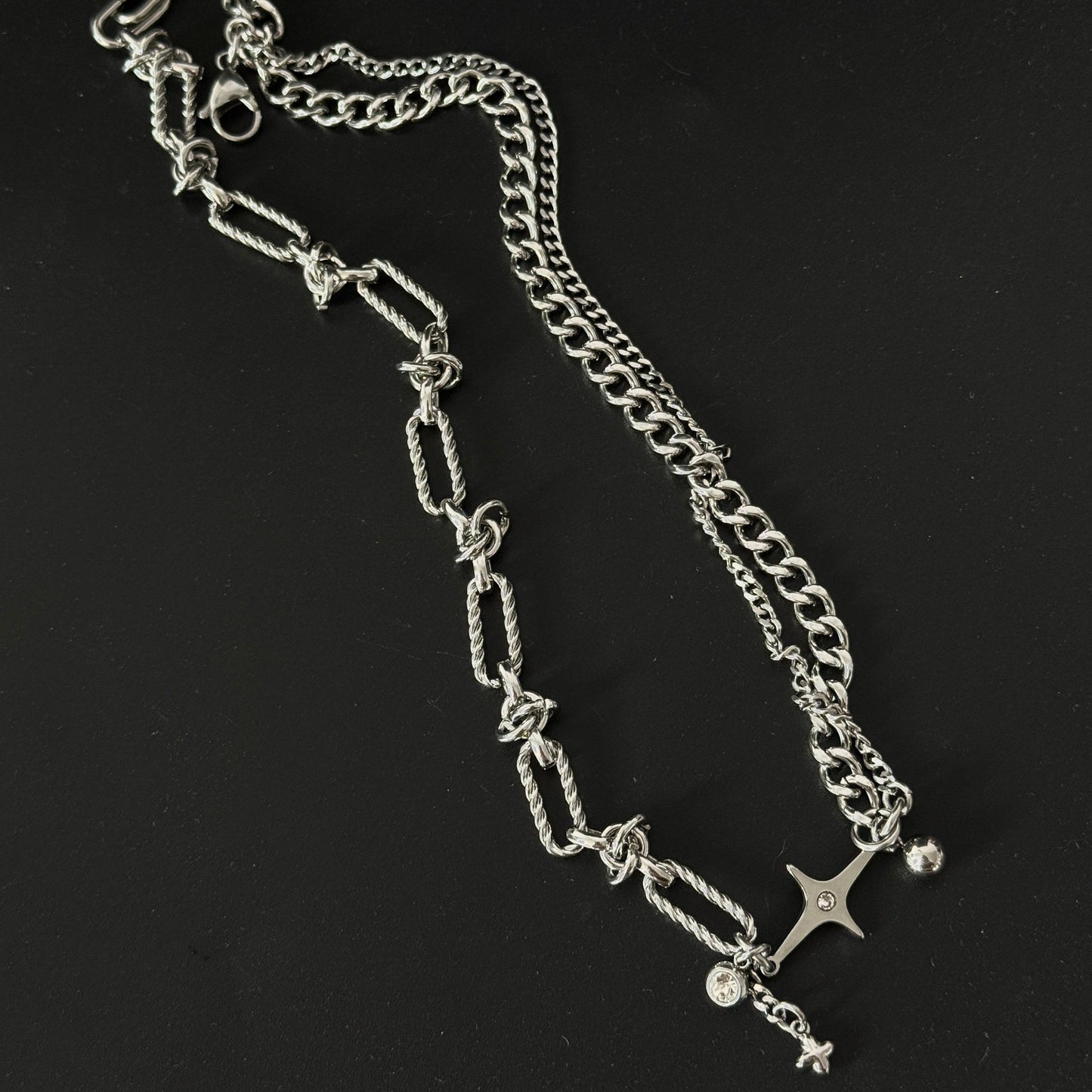 Layered Star adornment silver necklace lay flat