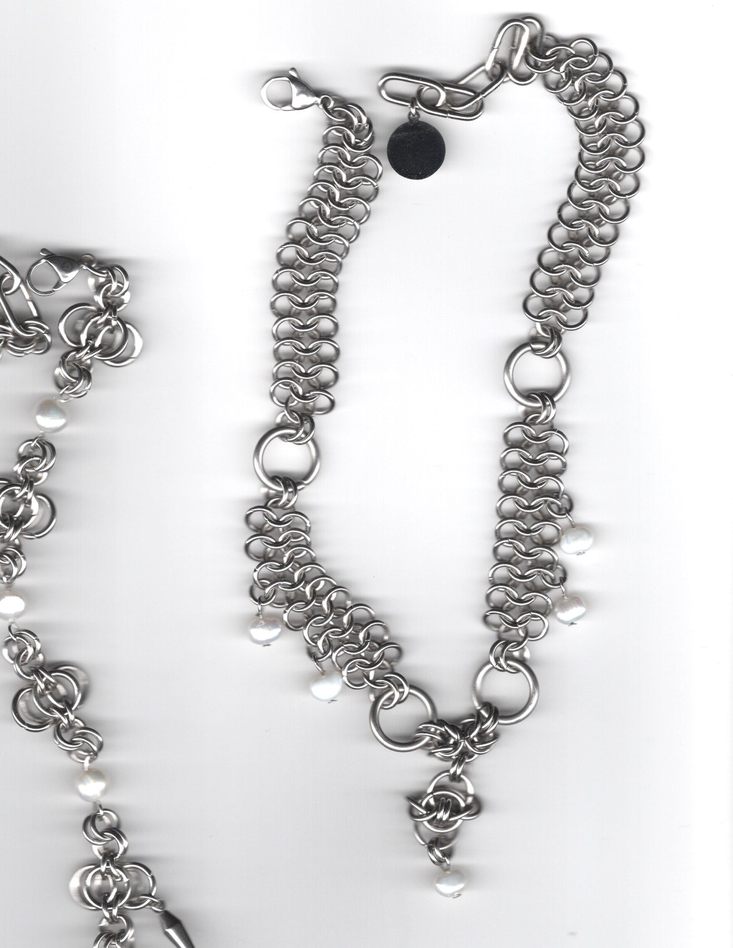 Silver chain necklace with floral charm on a white background