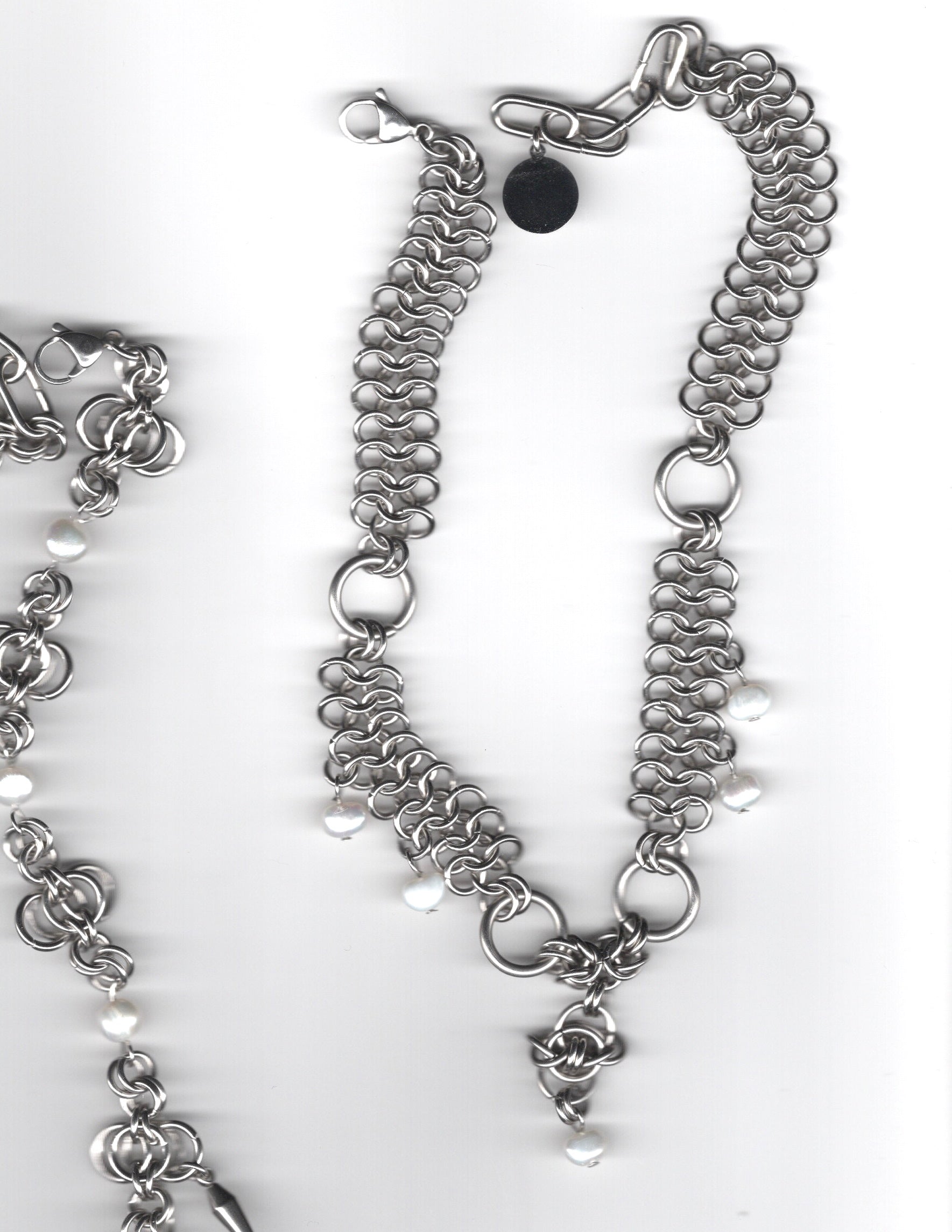 Silver chain necklace with floral charm on a white background