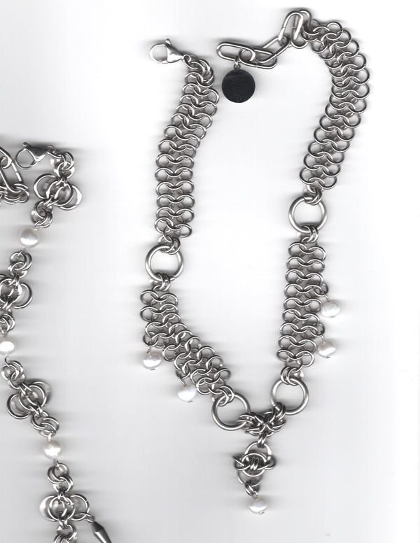 Silver chain necklace with floral charm on a white background