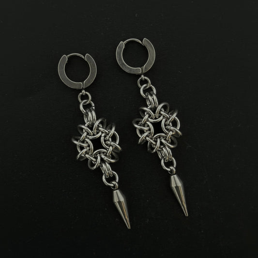 Pair of silver hoop earrings with chain and spike designs on a black background
