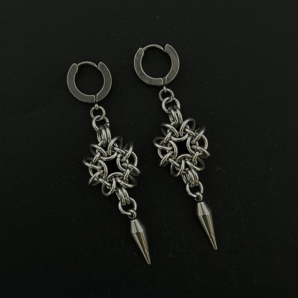 Pair of silver hoop earrings with chain and spike designs on a black background